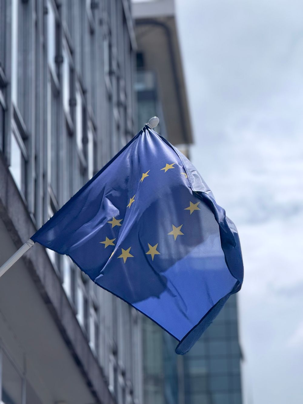 Wehende Europaflagge vor einem modernen Gebäude